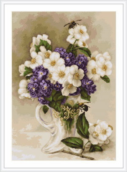 A floral tapestry embroidery kit depicting a vase with purple and white flowers, including a color photo of the finished picture, canvas, threads, needle, and instructions.