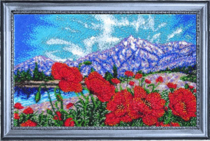 Beaded artwork of red flowers and mountains in a landscape