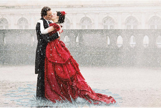 Couple in formal attire embracing in a snowy scene with a blurred architectural background