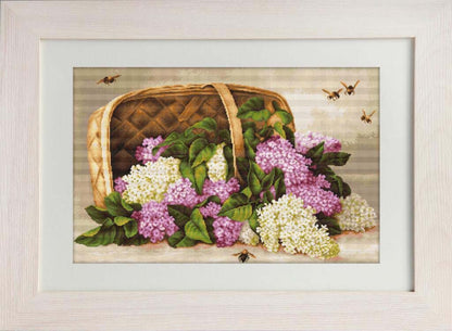 Framed artwork of a wicker basket with flowers and bees on a wooden background