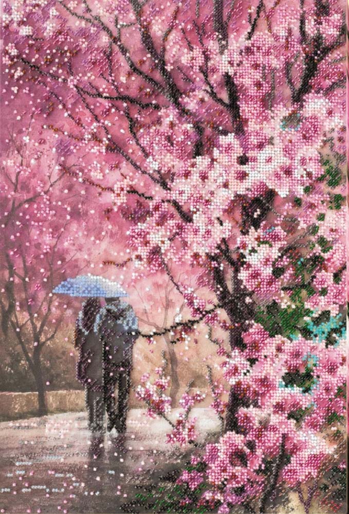 Two people under a blue umbrella walking through a cherry blossom garden with pink blossoms.
