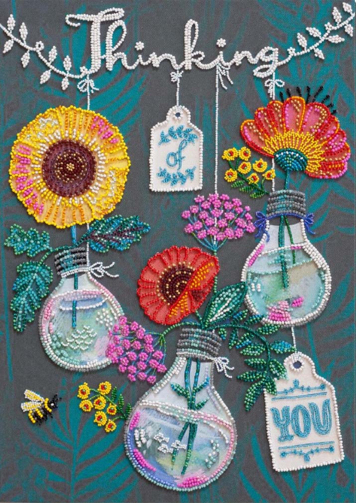 Embroidered design with flowers, light bulbs, and text on a dark background