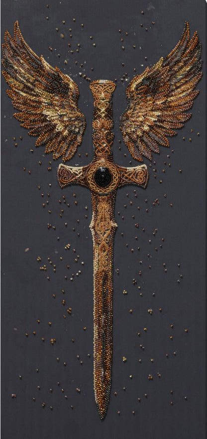 A winged sword design with outstretched golden-brown wings and a central dark gem, shown on a dark textured background with scattered small gold specks.