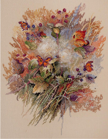 A cross stitch kit depicting a floral design with various colors and a needlework needle.