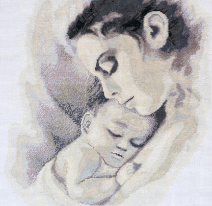 Cross stitch kit depicting a mother embracing a sleeping child, using grayscale and beige tones.