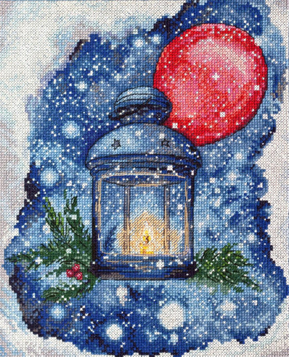 A cross stitch kit depicting a lantern with a red balloon and Christmas decorations against a blue background with snow.