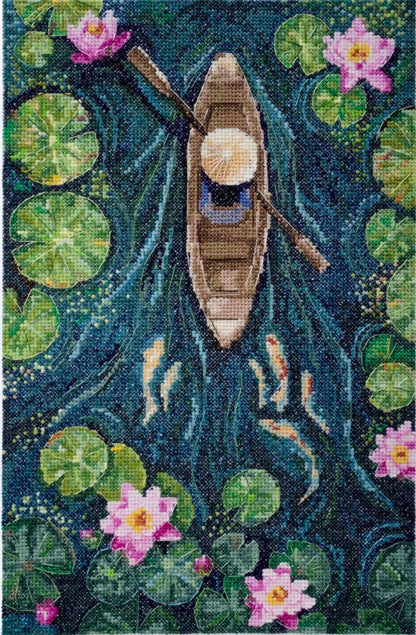 A cross stitch kit depicting a boat on a body of water with green lily pads and pink flowers.