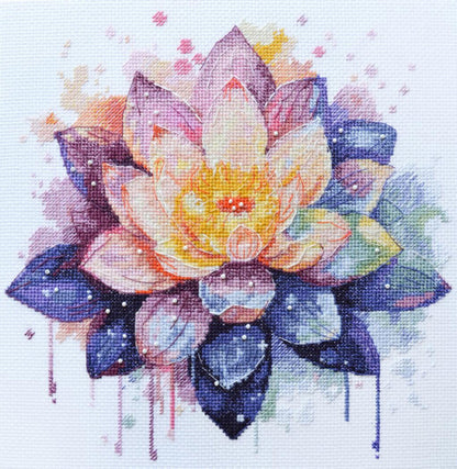 A completed cross stitch kit depicting a colorful lotus flower with pink, purple, and yellow petals on a white background with some water droplet details.