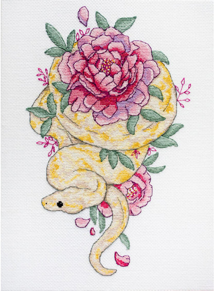 A cross stitch kit depicting a snake with floral elements, primarily in pink and green colors.