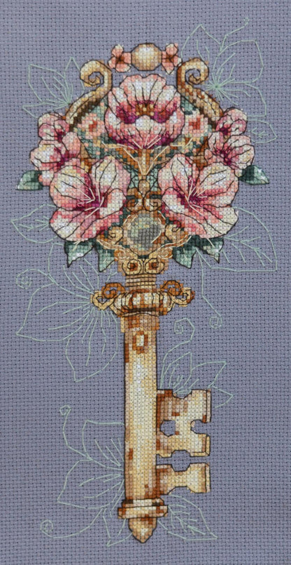 Counted cross stitch kit depicting a floral key design on a piece of canvas.