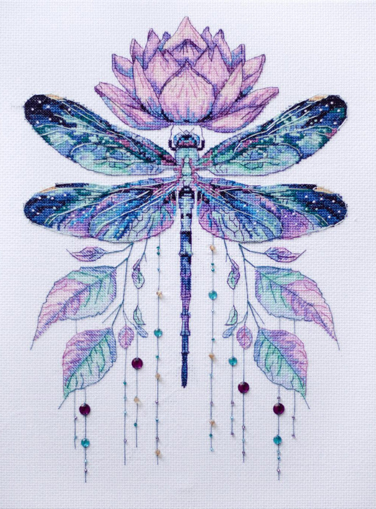 Cross-stitched design of a dragonfly with a lotus flower on a white background