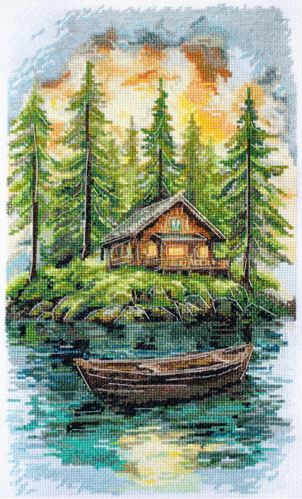 Cross-stitched depiction of a cabin by a lake with trees in the background