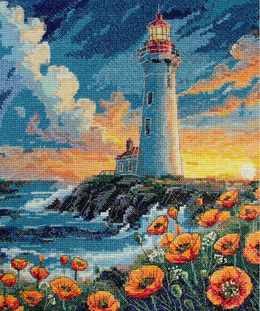 Cross-stitched lighthouse scene with flowers and sunset