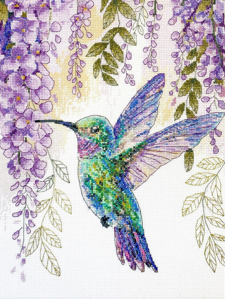 Colorful hummingbird surrounded by wisteria flowers on a cross-stitch pattern