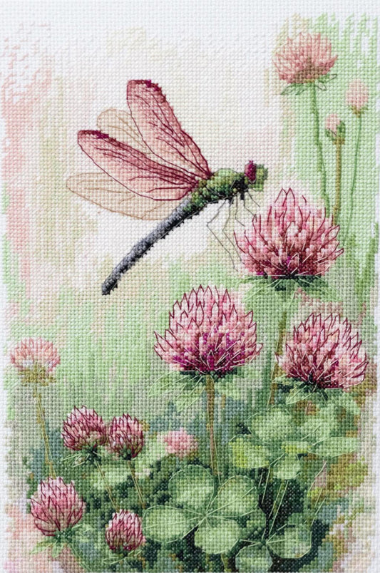 Cross-stitched design of a dragonfly and pink flowers on a white background