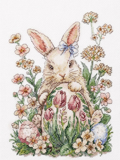 Cross-stitched design of a bunny with flowers and eggs