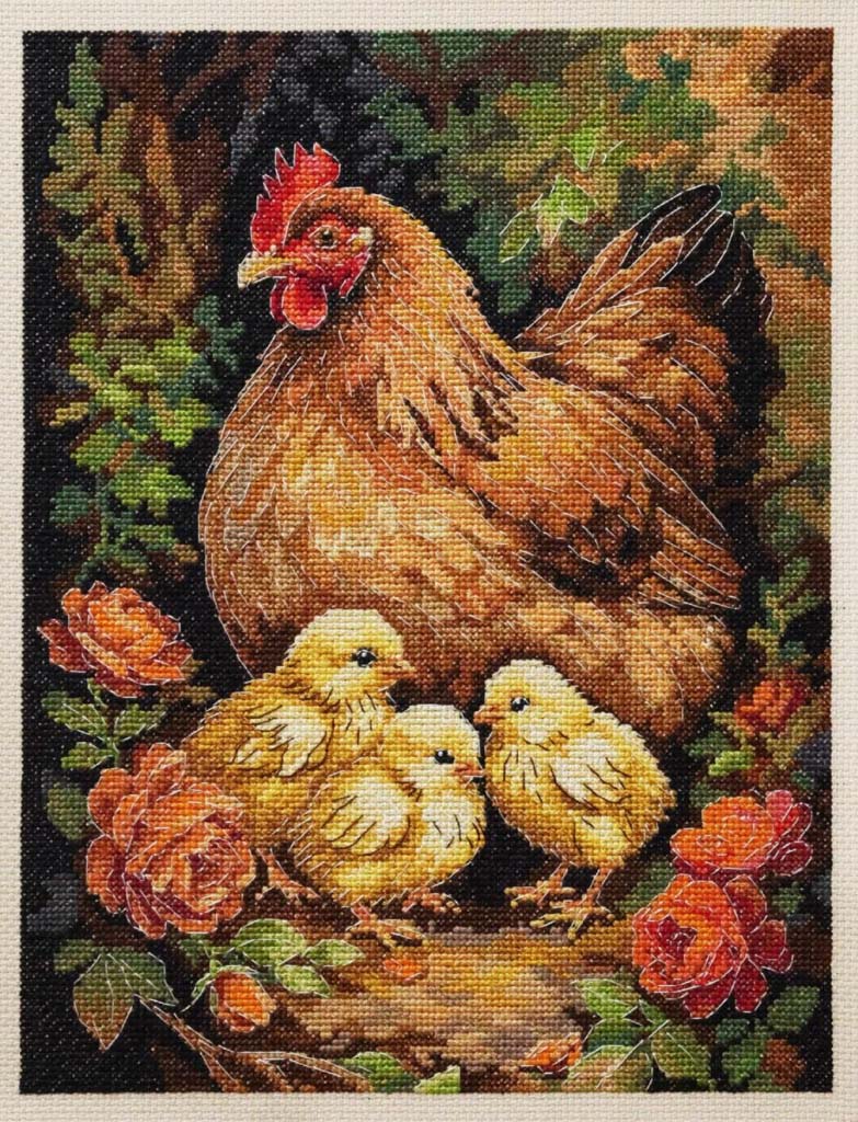 Cross-stitched picture of a rooster with three chicks in a garden setting.