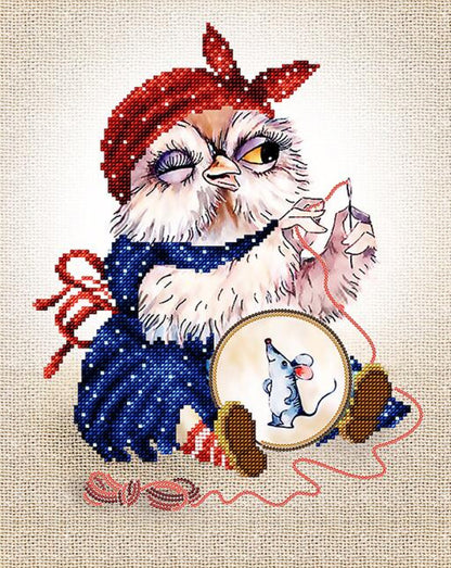 A bead embroidery kit depicting an owl wearing a red scarf and blue dress, sitting with a needle and thread on a beige background.