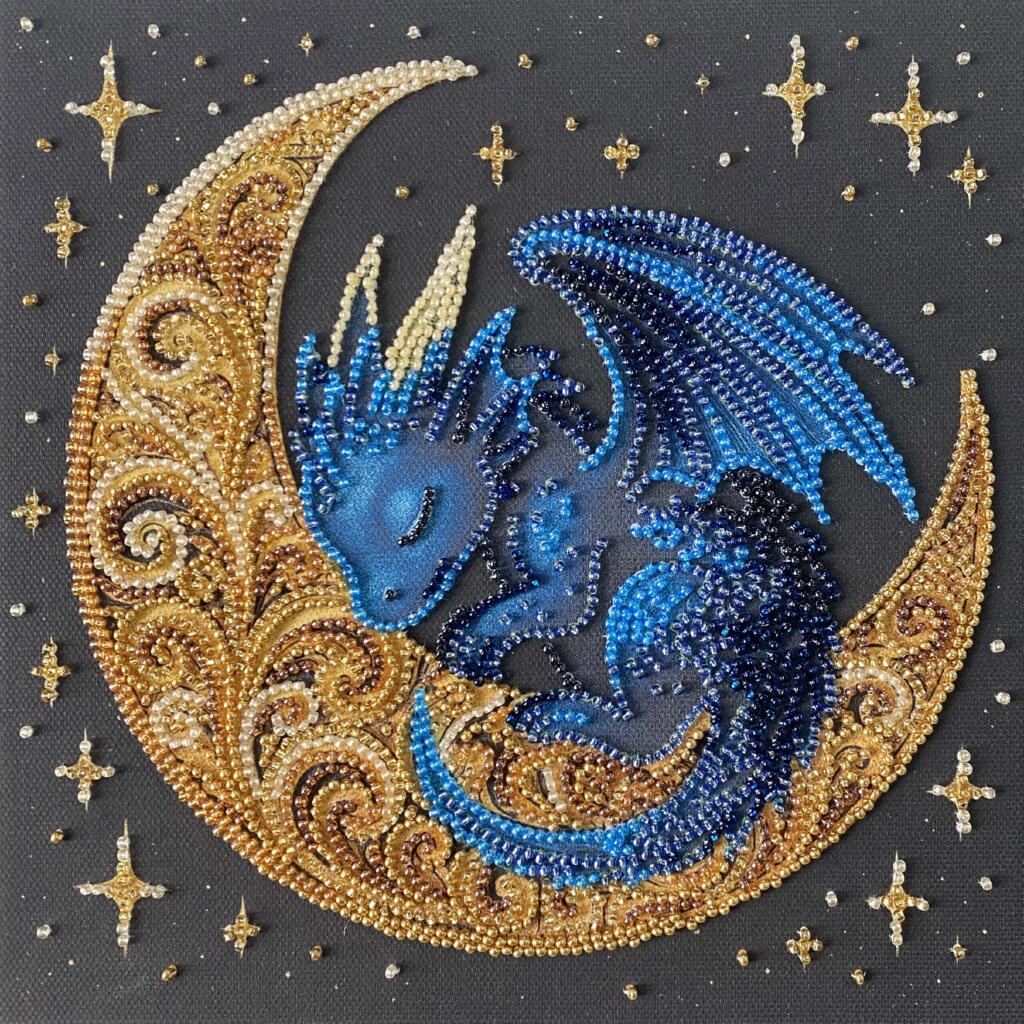 Decorative piece with a blue dragon on a gold crescent moon surrounded by stars.