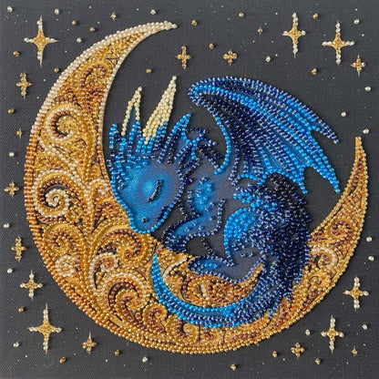 Decorative piece with a blue dragon on a gold crescent moon surrounded by stars.