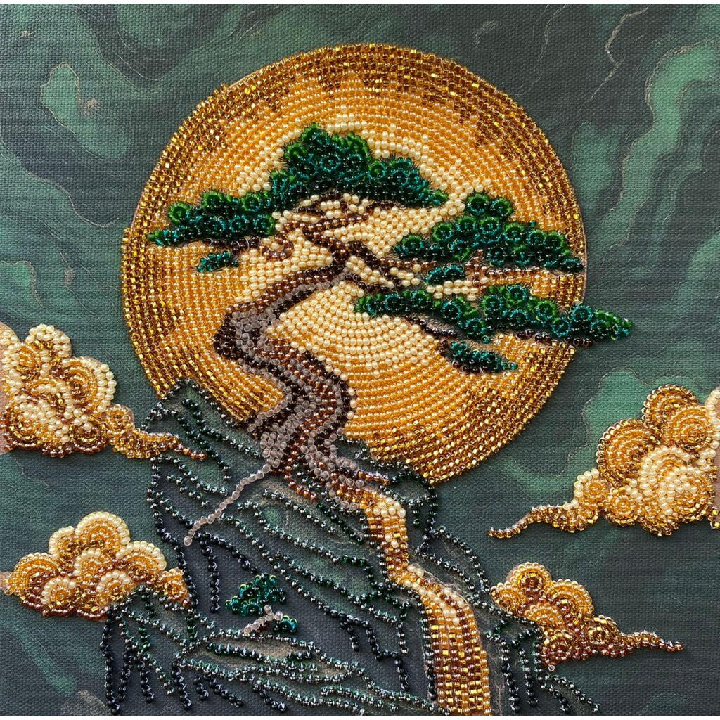 Beaded artwork of a tree with a full moon and clouds on a dark background