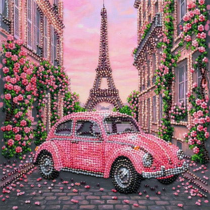 Decorative diamond painting of a pink car and Eiffel Tower with floral decorations.
