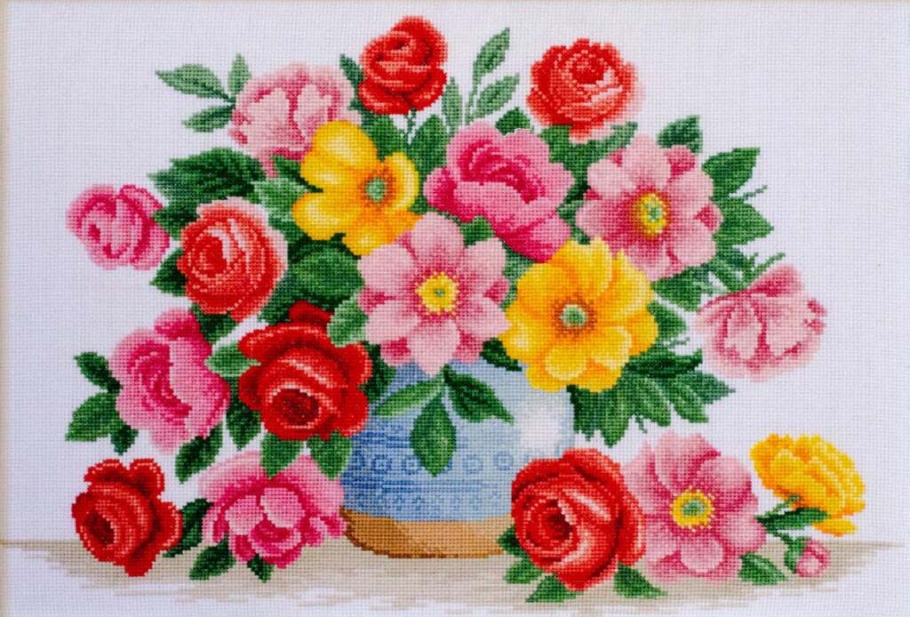 Cross-stitched pattern of a bouquet of flowers with red, pink, and yellow roses on a white background.