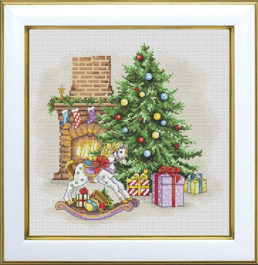 Cross-stitched scene of a child in front of a Christmas tree with presents and a rocking horse.