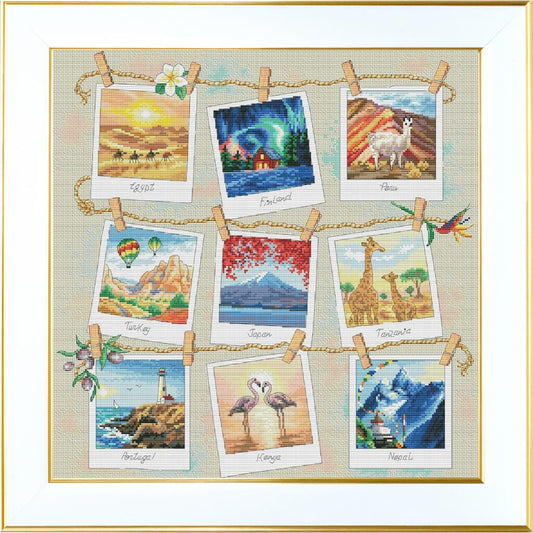 Cross-stitched landscape designs on paper with clothespins against a white background