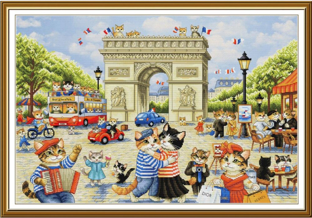 A framed illustrated scene of anthropomorphic cats in Paris, with the Arc de Triomphe in the background, people sitting outdoors, cars, bicycles, and a red double-decker bus. The artwork is shown within a gold-toned frame on a white background.