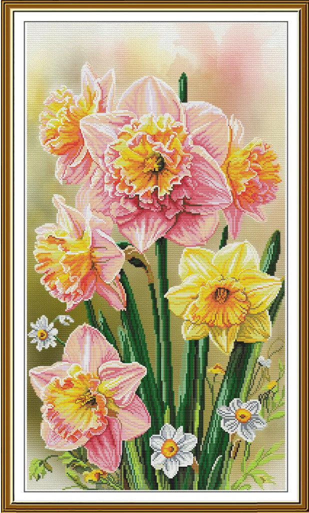 A framed floral artwork showing pink and yellow daffodils with green stems on a soft cream background, enclosed in a gold-toned frame.