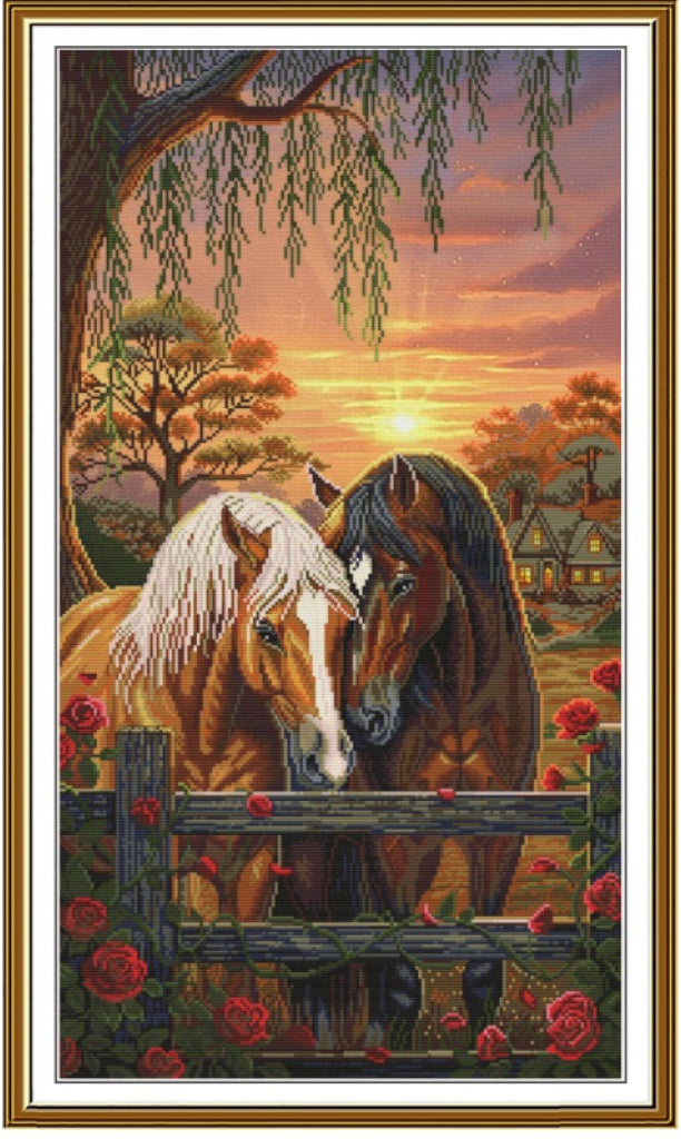 A framed art print depicting two horses at a sunset, with a fence, roses, trees, and a small house in the background. The artwork is enclosed in a white mat and a gold-toned frame.