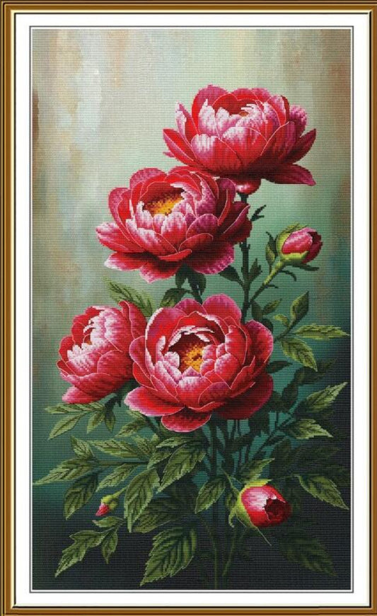 A framed needlepoint canvas featuring a detailed floral design of four red and pink peonies with green leaves on a textured green and beige background, enclosed in a gold-toned frame.