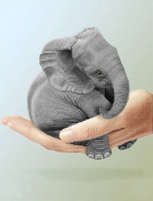 Small elephant toy held in a hand against a light background