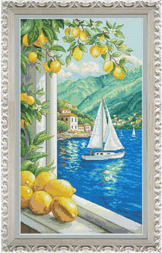 Framed needlepoint canvas featuring a Mediterranean coastal scene with lemons, a sailboat on blue water, green hills, and white buildings, surrounded by an ornate silver frame.